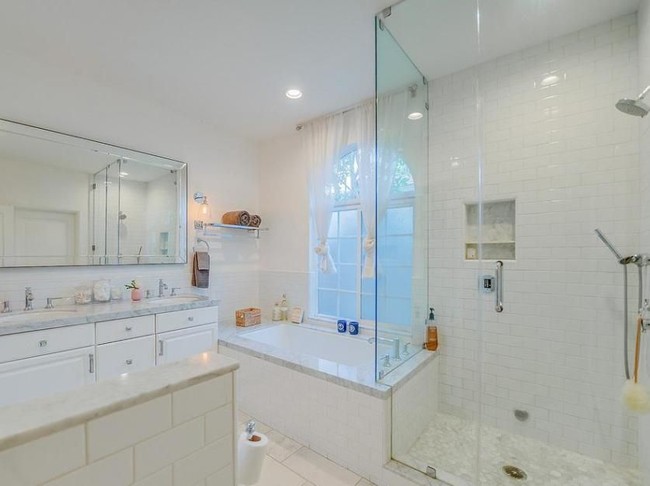 Kamar mandi utama yang hadir dengan bathtub dan shower. Pemakaian keramik putih sebagai dinding menciptakan kesan chic. (Foto: Dok. Variety)