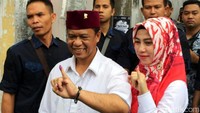Anton Charliyan dan Ajeng Anjarsari menunjukkan jari yang telah dicelupkan ke tinta sebagai tanda telah melakukan pencoblosan.