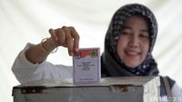 Salah seorang pemilih memasukan surat suara ke dalam bilik suara.