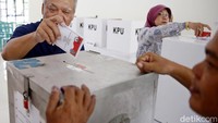 Basuki memasukkan surat suara ke dalam kotak suara yang telah disediakan.
