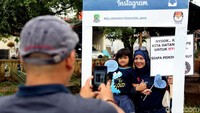 Usai melakukan pencoblosan di TPS 1 Kelurahan Pekayon, Bekasi Selatan, Rabu, (27/06/2018), para warga melakukan selfie di booth bingkai Instagram.