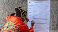 Petugas mencatat hasil penghitungan suara.