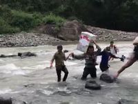 Brigpol Nasaruddin saat menyeberangi sungai