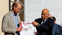 Pangeran William juga mengunjungi kota Ramallah di West Bank, Palestina dan mendapat cinderamata berupa jersey timnas Palestina. Mussa Qawasma/Reuters.