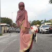 Sebuah video yang memperlihatkan wanita bermain free style street ball jadi viral. Tampilan wanita itu sangat unik, ia memakai baju kurung dan hijab tapi jago bermain bola. Foto: Instagram/Qhouirunnisa