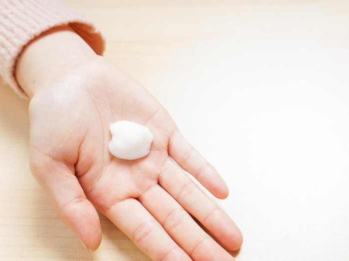 ilustrasi wanita pakai skin care womans hand touching on the cream for applying