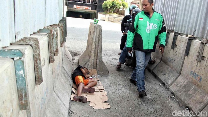 Seorang anak gelandangan tidur beralaskan kardus di bawah Depo LRT Kepala Gading, Jakarta Utara, Kamis (28/6). Bocah tersebut tampak kelelahan.