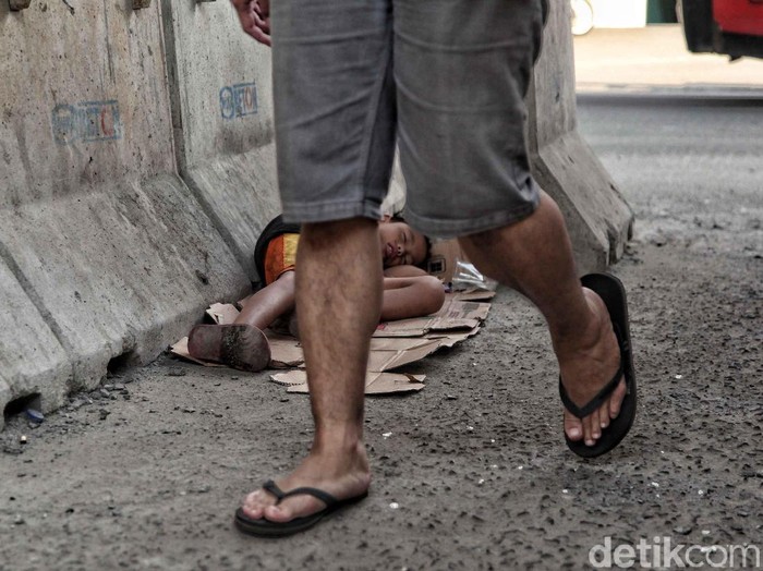 Seorang anak gelandangan tidur beralaskan kardus di bawah Depo LRT Kepala Gading, Jakarta Utara, Kamis (28/6). Bocah tersebut tampak kelelahan.