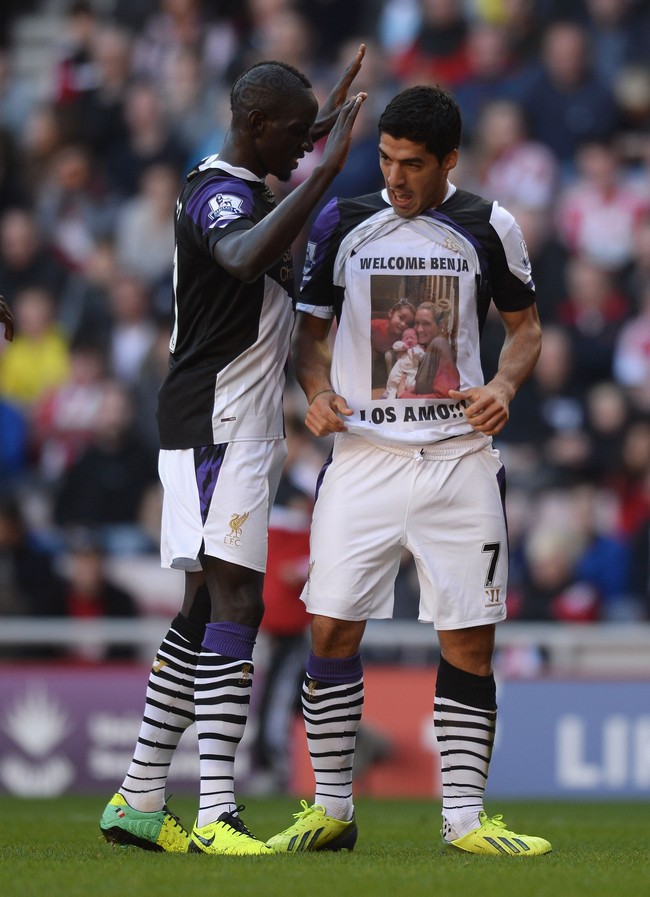 Luis Suarez begitu cinta pada istri dan anak-anaknya. Kecintaannya itu pun tak segan ditunjukkannya pada khalayak. Saat masih memperkuat Liverpool dan bertanding melawan Sunderland, di balik jersey yang dipakainya, dia mengenakan kaus yang dihiasi potret istri dan kedua anaknya. Pada potret tersebut tampak sang istri menggendong anak laki-laki mereka yang baru lahir. “Welcome Benja. Los Amo,” demikian tulisan di kausnya yang berarti ‘selamat datang Benja (nama anak laki-lakinya). aku mencintai mereka.’ Foto: Dok. Getty Images, Instagram