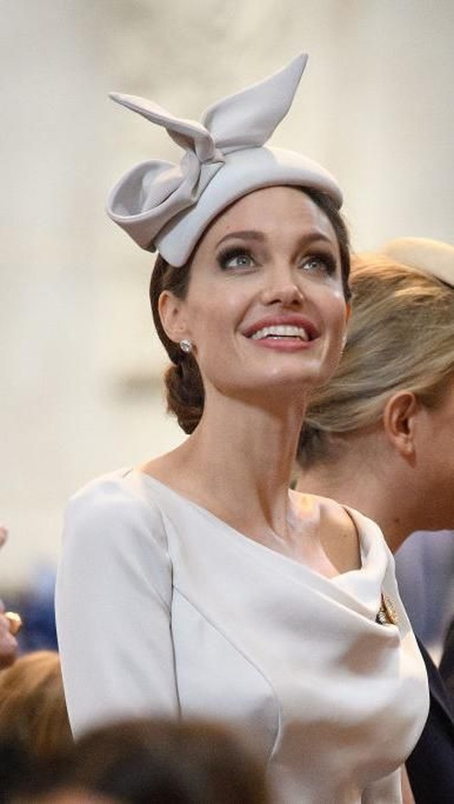 Angelina Jolie mencuri perhatian dengan dress klasik dan topi bergaya bangsawan Inggris. Gayanya menyaingi Meghan Markle.  Foto: dok. Getty Images