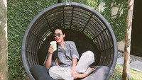 Duduk santai, wanita yang mengaku gemar makanan Italia ini terlihat sedang mencicip caffe latte di Lloyds Inn. Foto: Instagram @alikaislamadina
