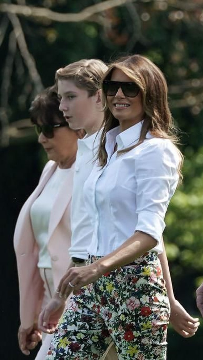 Seperti biasa Melania Trump muncul dengan gayanya yang elegan. Mantan model itu mengandalkan blus putih yang dipadu dengan celana panjang bermotif floral.  Foto: dok. Getty Images