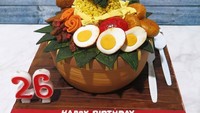Cake berbentuk nasi tumpeng komplet dengan ayam goreng, telur, tempe dan sambal ini adalah cake buatan Sugar Ministry Artisan Cake Shop. Lokasinya ada di PIK, toko kue ini menjual beragam sajian cake ulang tahun yang bisa dipesan sesuai selera. Foto: Instagram @sugarministry