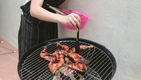 Nas nas panaaassss, tulis Tya di keterangan foto. Santai pakai kaos, istri Asyraf Khalid ini asik mengolesi bumbu ayam bakar. Foto: Instagram tyaarifinnw
