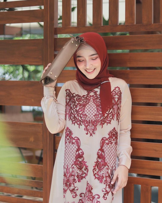 Agar terlihat lebih istimewa, kita juga bisa menyematkan aksesori seperti bros pada hijab segi empat voile yang kita pakai. Kesan glossy atau ‘bling-bling’ memang identik pada busana kondangan di Indonesia. Foto: Instagram/AyuIndriati