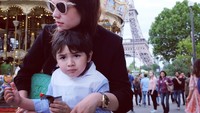 Berlatar menara Eifel di salah satu taman bermain. Carissa pun tampak asyik berfoto, tapi Quenzino malah sibuk dan fokus menikmati camilannya. Foto: Instagram @carissa_puteri