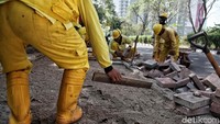 Pekerja meratakan tanah dilokasi yang akan dipasangi konblok.