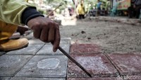 Seorang petugas melakukan pemasangan konblok.