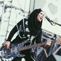 Gitaris cantik itu tampil memakai hijab instan berbentuk hoodie. Hijab berwarna hitam dan berbahan kaos itu ia padukan dengan scarf bermotif tengkorak di bahunya. Foto: Instagram/ChuaKotak