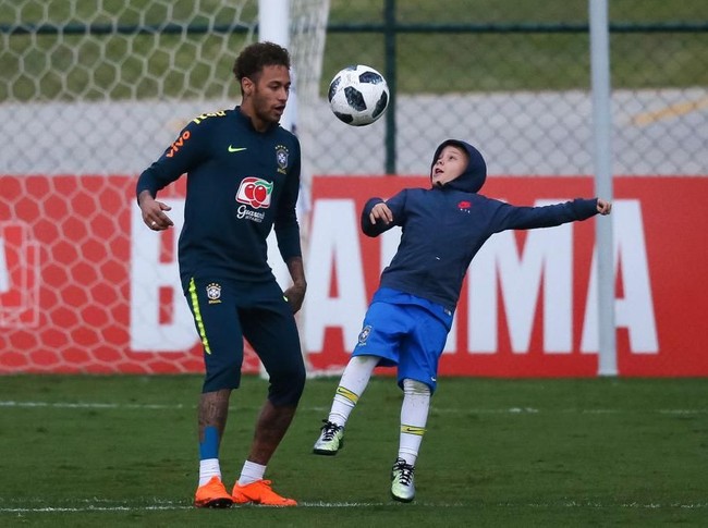 Like father like son. Neymar bermain bola bersama anaknya usai sesi latihan timnas Brasil jelang Piala Dunia 2018. (Foto: Getty Images)