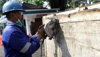 Seorang petugas melakukan pemotongan bak truk yang kelebihan beban itu dengan menggunakan gergaji mesin.
