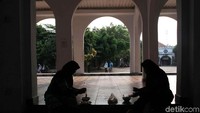 Dua orang pengunjung menyantap makanan disekitar komplek makam Mbah Priuk.