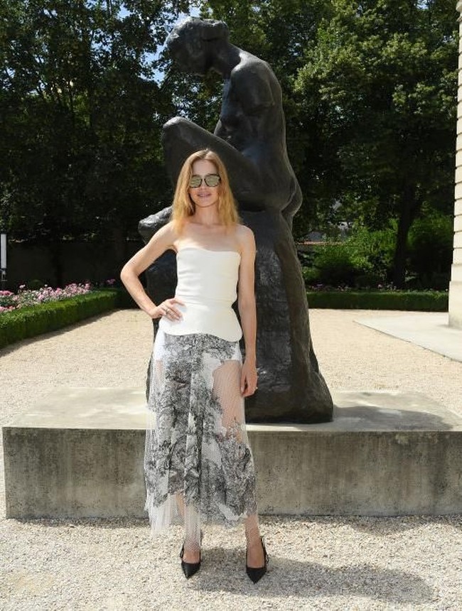 Model Rusia Natalia Vodianova mencoba mencuri perhatian dalam balutan gaun dengan rok transparan. Busananya lantas dipadukand dengan pointed heels, berikut kacamata hitam. (Foto: Getty Images)