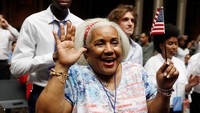 Senyum bahagia menghiasi para warga negara Amerika baru ini. Setelah sekian lama berjuang mendapatkan kewarganegaraan, akhirnya mereka resmi memiliki Kartu Hijau atau Kartu Penduduk Permanen yang menandakan mereka sebagai warga negara AS. Shannon Stapleton/Reuters.