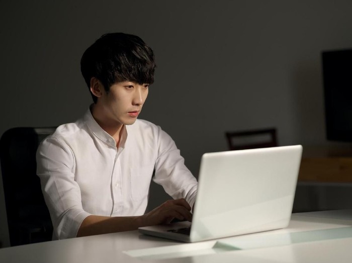 ilustrasi kerja lembur Young man working on the laptop at night