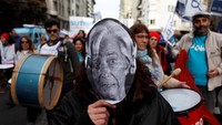 Ribuan guru di Argentina melakukan aksi long march menuju Kantor Kementerian Pendidikan Argentina di Buenos Aires, Argentina, Selasa (03/7/2018) waktu setempat. Diantaranya mengenakan topeng wajah Direktur Dana International Monetary Fund (IMF) saat melakukan long march. Martin Acosta/Reuters.