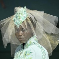 Penampilan Adut juga dilengkapi headpiece dengan veil bernuansa keemasan yang menciptakan kesan glamor. (Foto: Getty Images)
