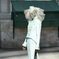 Adut muncul dalam balutan gaun pengantin dengan pilihan warna yang nonkonvensional. Bukan putih tapi hijau. Gaun bersiluet jaket tersebut hadir dengan atasan berkerah tinggi, dengan detail embellishment bernuansa floral yang menghiasi bagian depan dan pinggir. (Foto: Getty Images)