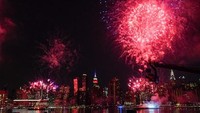 Malam harinya kota New York disinari cahaya kembang api untuk merayakan Hari Kemerdekaan Amerika Serikat. Tak tanggung-tanggung puncak gedung The Empire State Building pun berubah warna menjadi warna bendera Negeri Paman Sam itu. Munoz Alvarez/Getty Images.