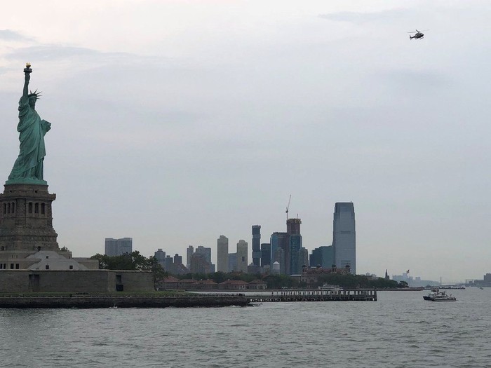 Emergency responders are seen as a protester climbs on the base of the Statue of Liberty in New York, New York, U.S., July 4, 2018 in this picture obtained from social media. Twitter/@sarah_eyebrows/via REUTERS THIS IMAGE HAS BEEN SUPPLIED BY A THIRD PARTY. MANDATORY CREDIT. NO RESALES. NO ARCHIVES