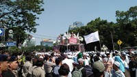 assa aksi beberapa kali terdengar meneriakkan takbir saat berjalan menuju ke Bareskrim. Selain itu, mereka juga membawa bendera, seperti bendera merah-putih, bendera Palestina, dan sejumlah bendera berwarna hitam dengan tulisan arab. (Foto: Nur Azizah Rizki Astuti/ detikcom)