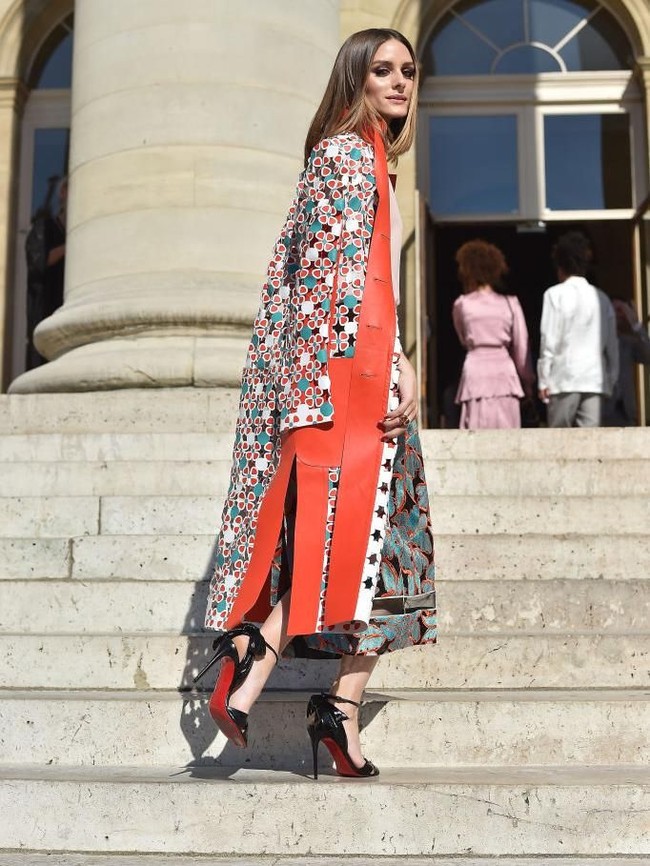 Juga hadir di fashion show Fendi Couture, sosialita muda Olivia Palermo. Dress motif floral berbalut coat oranye, berikut heels Louboutin dengan aksen pita pada bagian belakang jadi andalannya. (Foto: Getty Images)