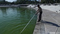 Pekerja membersihkan kolam di sekitar Monumen Pembebasan Irian Barat.
