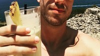 Segelas smoothies mangga dan nanas jadi minuman teman santai Jordan kali ini. Ia berjemur di pinggir pantai. Tak lupa kaca mata hitam untuk membuatnya tampil keren. Foto: instagram @jhenderson