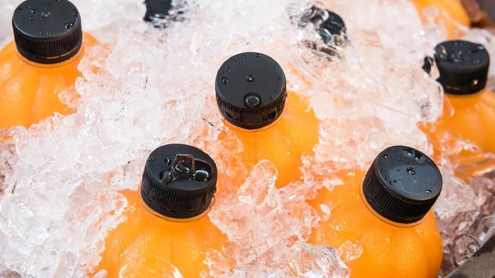 641022762 fresh orange juice in plastic bottled chilled in wooden ice bucket