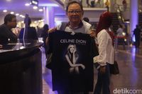 Seorang penggemar membeli kaos Celine Dion.
