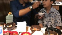 Mantap! Meskipun disibukkan dengan berbagai aktivitas, Hengky masih sempat menjemput putranya pulang sekolah lalu mengajaknya makan bersama. Ini saat Hengky menyuapkan makanan.  Foto: instagram @hengkykurniawan