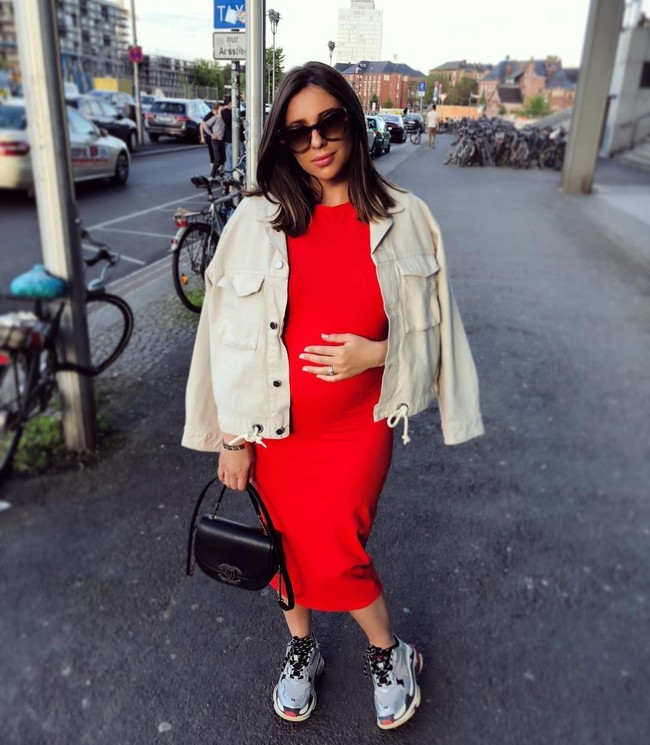 Gaya ibu hamil kekinian ala Shanga. Tampak perempuan 26 tahun itu memakai dress merah yang dibalut jaket oversized, ditambah tas hitam Chanel, dan sneakers biru.  Foto: Dok. Instagram/Shanga Forsberg