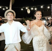 Penampilan Nadine di acara resepsi malam harinya jauh lebih modern. Mengenakan gaun dengan hiasan bordir dan guntingan cold shoulder yang elegan. Foto: Dok. Instagram/@rzbyphotography