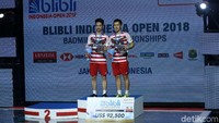 Kevin/Marcus menunjukkan medali juara Indonesia Open 2018.