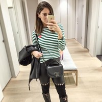 Shanga mencoba tampil edgy dengan celana kulit beraksen tali yang dipasangkan dengan kaus hijau bergaris dari Commes des Garcons serta tas Chanel. Foto: Dok. Instagram/Shanga Forsberg