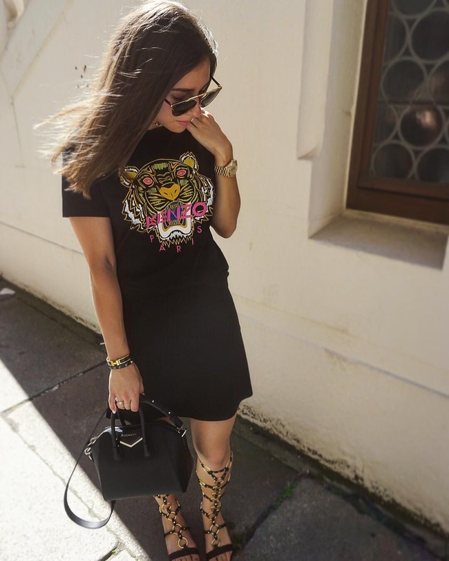 Berbusana serba hitam bukan sesuatu yang membosankan bila melihat gaya Shanga yang satu ini. Ia memakai kaus Kenzo dengan motif kepala harimau khasnya, berpadu rok hitam, serta sendal gladiator beraksen emas. Di jajaran aksesori, tas Givenchy, gelang Hermes, jam tangan emas dan kacamata aviator jadi andalan.  Foto: Dok. Instagram/Shanga Forsberg