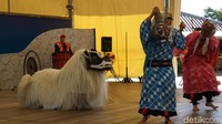 Nah di tengah-tengah tarian singa ini ada dagelannya. Dua aktor bertopeng lucu muncul dari belakang panggung, mereka mendekati sang singa dan mengodanya (Masaul/detikTravel)