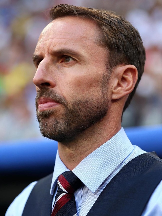 Begitu pula dasinya. Haram hukumnya bagi pelatih 47 tahun itu bila dasinya tak bermotif garis merah, putih dan hitam. (Foto: Getty Images)