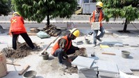 Para pekerja terlihat sibuk mengerjakan pelebaran trotoar tersebut.