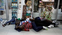 Para penumpang tak bisa meninggalkan bandara karena keadaan diluar pun tak aman, sehingga mereka pun harus menunggu di bandara. Andres Martinez Casaf/Reuters.
